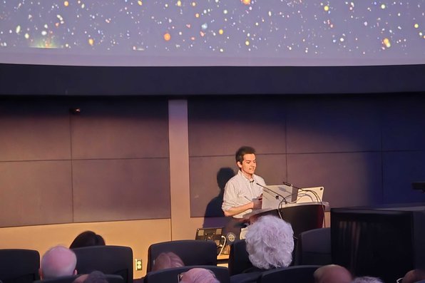 Graduate Student at podium giving lecture in planetarium