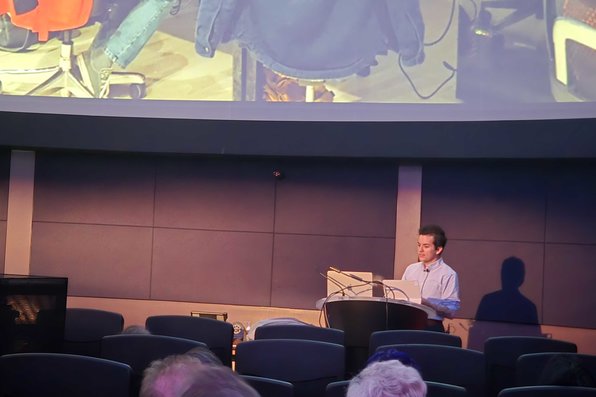 Student at podium giving lecture to audience